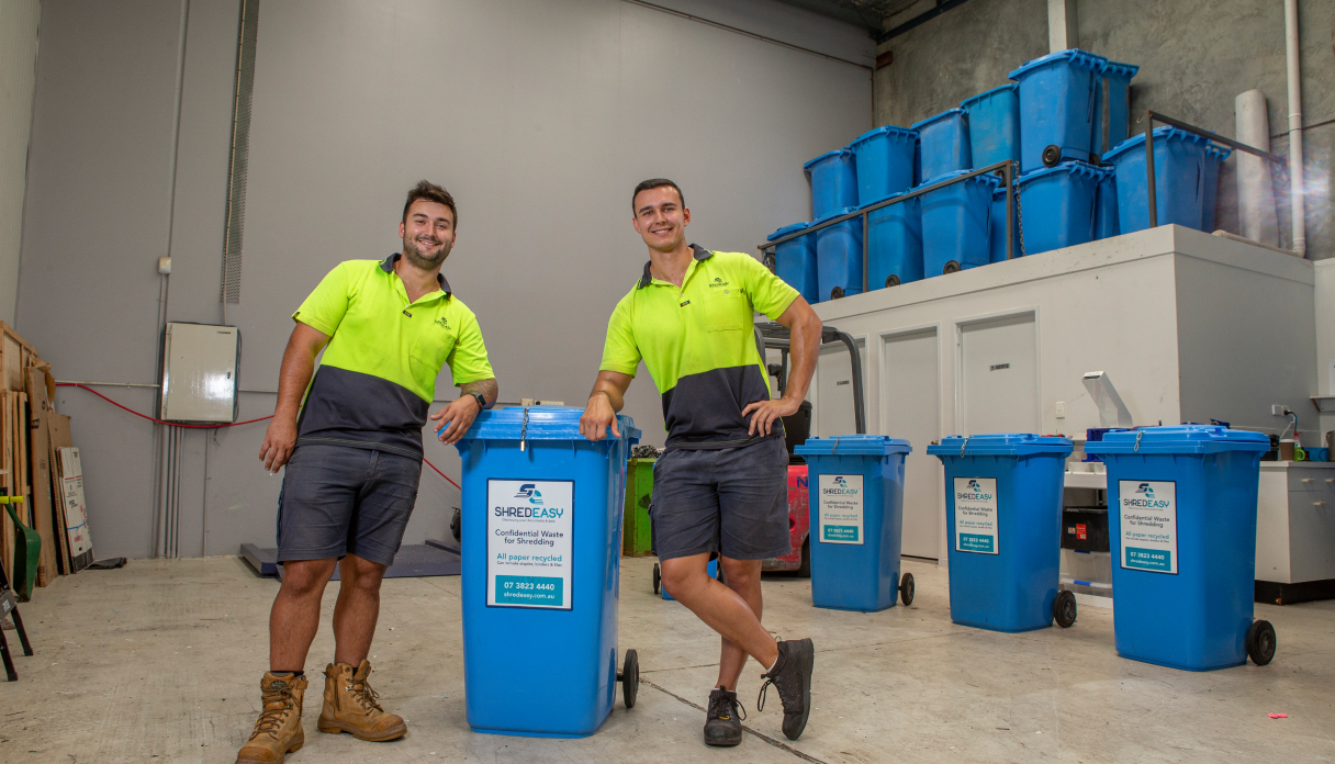Workers with Shred Easy bins in warehouse for confidential paper shredding